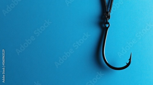 A Black Fishing Hook Hanging from a Rope on a Blue Background