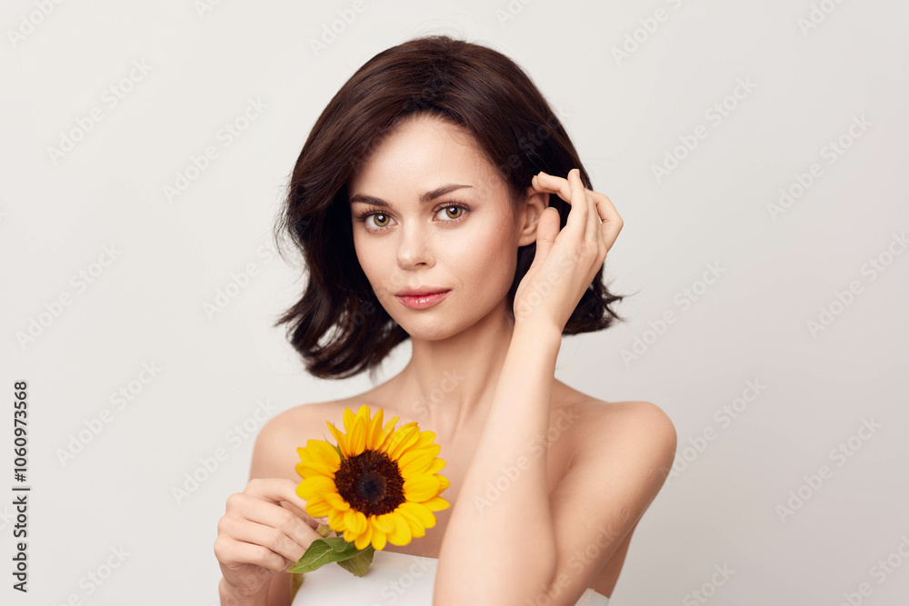 Beautiful young woman holding a sunflower on a white background Beautiful young woman holding a sunflower on a white background