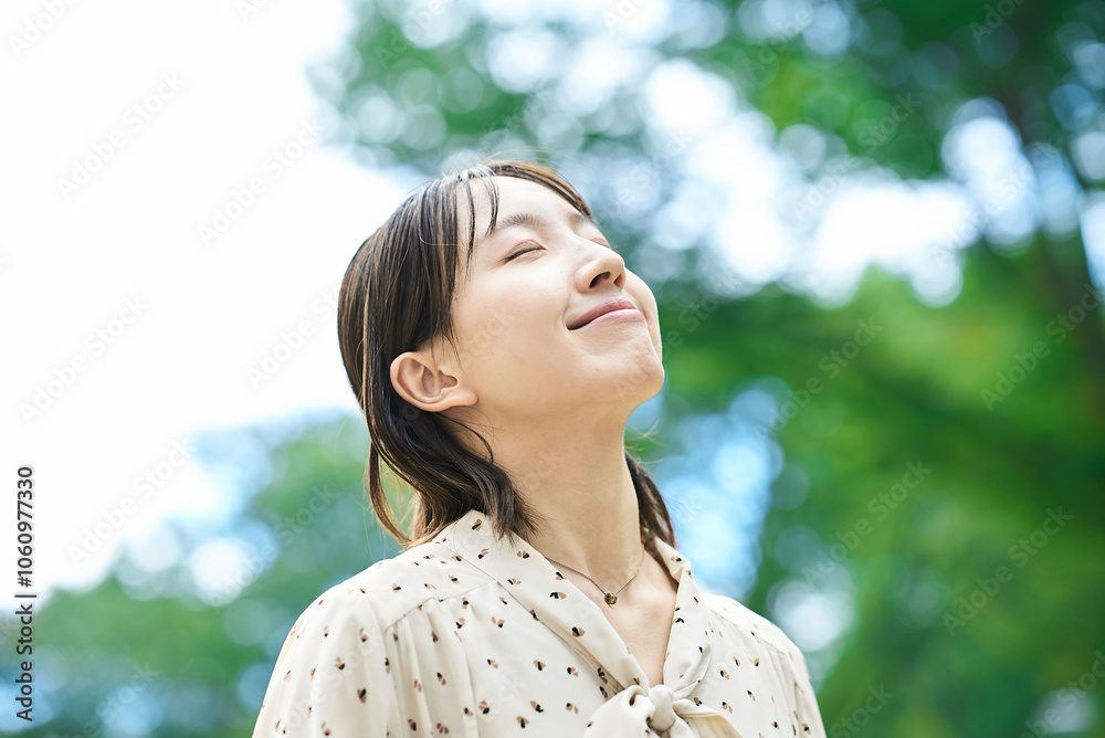 Fototapeta premium 緑地でリラックスする若い女性のポートレート