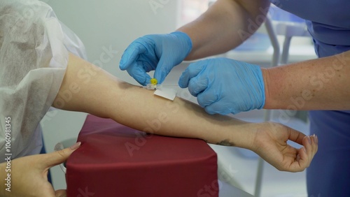 Photography Medical professional inserting an intravenous catheter into a patient's arm for