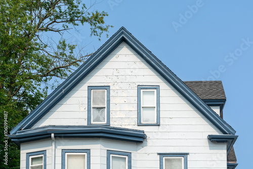 Weathered facade of a two-story house with blue trim in Brighton, Massachusetts, USA