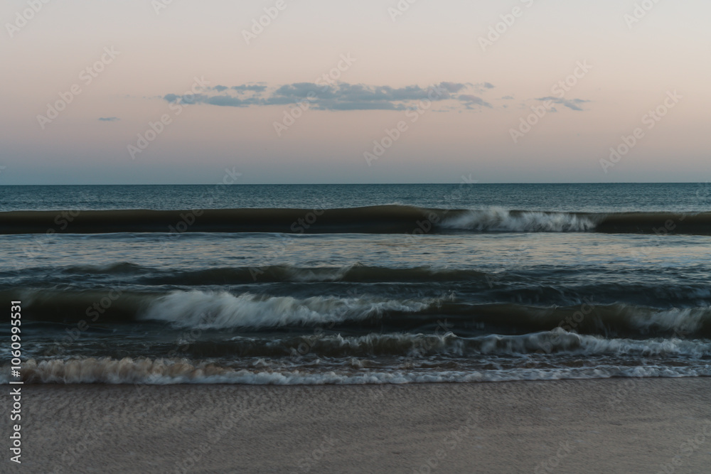 Smooth, blurred waves reflecting dusk light in serene tones. Smooth, blurred waves reflecting dusk light in serene tones.