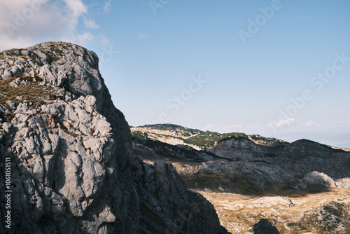 Beautiful mountain landscape with people hiking under the sun 
