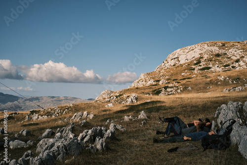 Beautiful mountain landscape with people hiking under the sun 