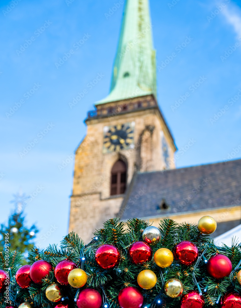 A festive scene with Christmas decorations in the foreground and the Cathedral of St. Bartholomew in Plzen, Czech Republic, in the background. A charming mix of tradition and holiday spirit