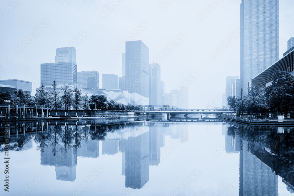 Fototapeta premium Serene Cityscape Reflections in a Misty Urban Environment