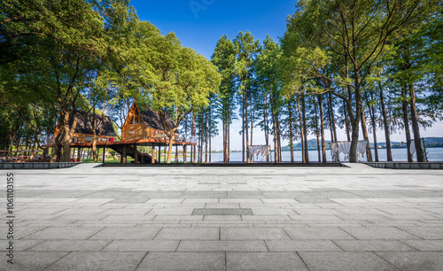 Obraz na plátne Serene Lakeside Pavilion Surrounded by Lush Greenery and Sunlit Waters