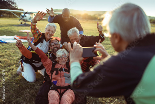 Diverse senior friends taking group photo after skydiving