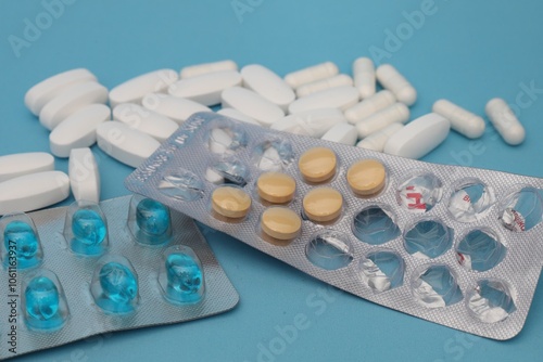 white tablets and a blister with blue capsules