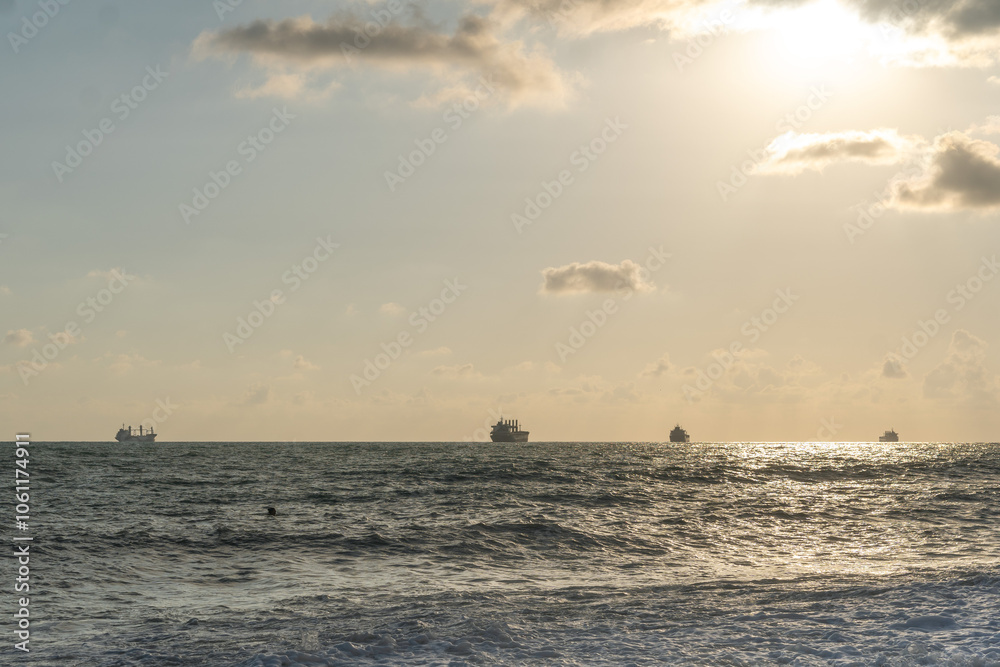 Sea waves roll onto the pebbly shore against the background of the evening sunset sky with clouds. Sea waves roll onto the pebbly shore against the background of the evening sunset sky with clouds.