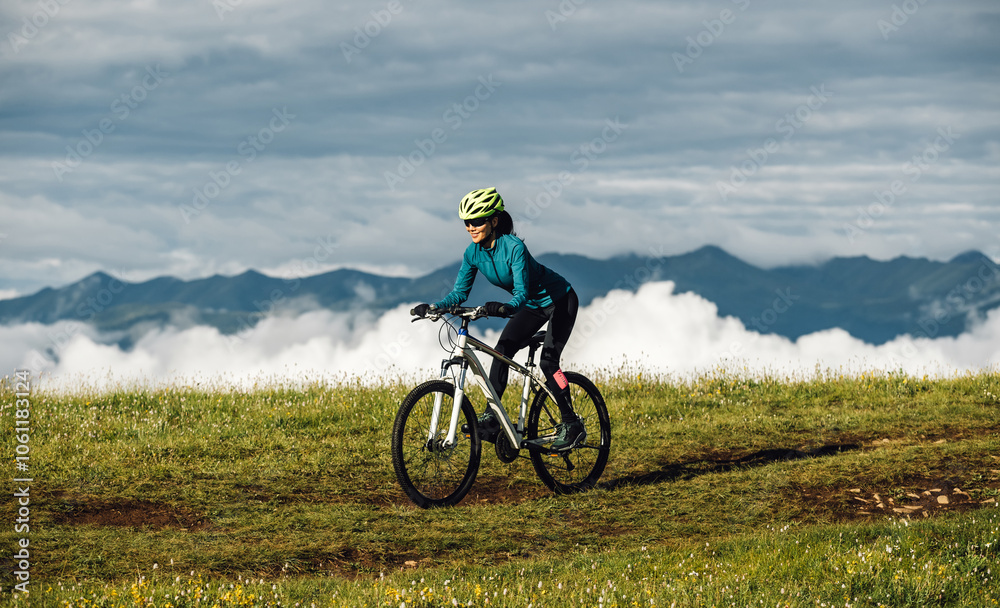 Asian woman riding mountain bike on beautiful mountain top Asian woman riding mountain bike on beautiful mountain top