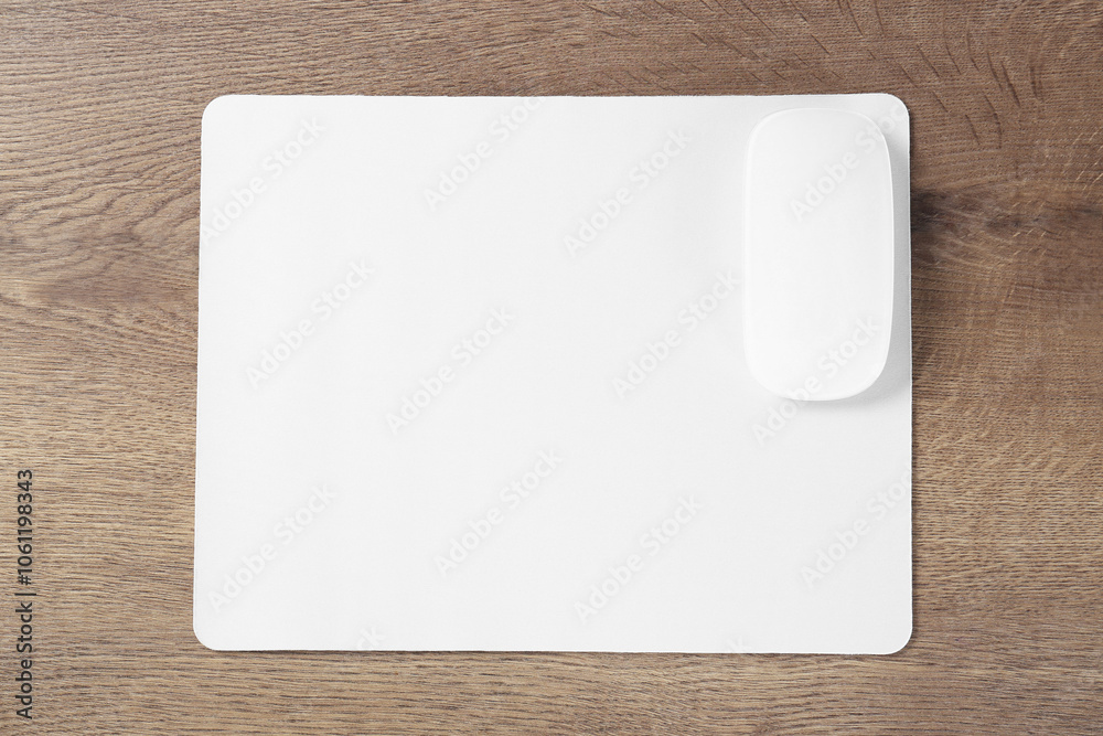 Computer mouse with mousepad on wooden table, top view Computer mouse with mousepad on wooden table, top view