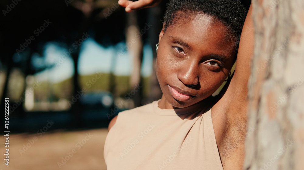 Close-up of attractive relaxed young woman standing near a tree in the park Close-up of attractive relaxed young woman standing near a tree in the park