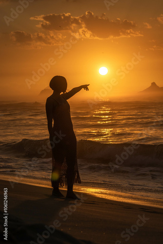 Silhouette girl pointing to the sunrise photo