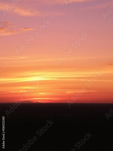 Vibrant gradient of golden, pink, and purple hues in a beautiful sunset over the horizon, dusk, golden, sunset