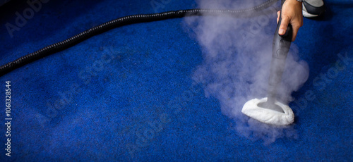 Janitor cleaning carpet with vacuum cleaner at home. A steam cleaner on the carpet.