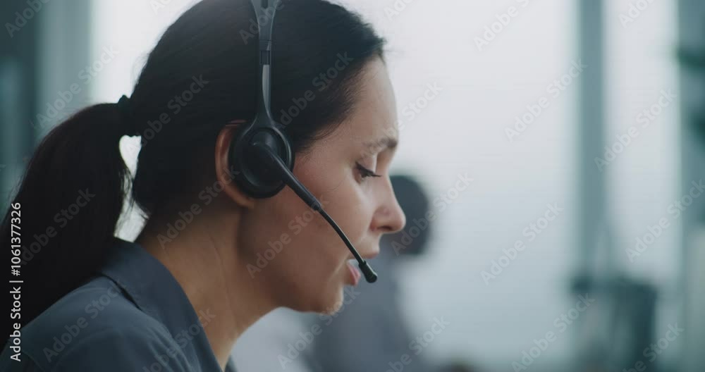 Female helpdesk specialist working in modern call center office: Close up portrait of Caucasian hotline operator using headset to talk with client, providing online technical support for customer.