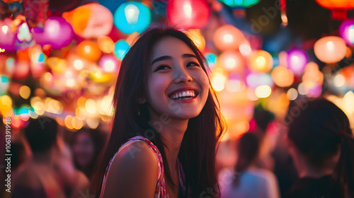 A young woman smiles brightly at a vibrant lantern festival, surrounded by glowing lanterns.