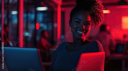 Smiling Woman Working on Laptop in a Brightly Lit Office