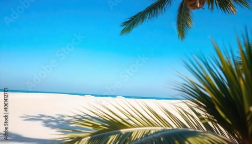 Bright tropical beach with blue skies, white sand, and palm fronds.