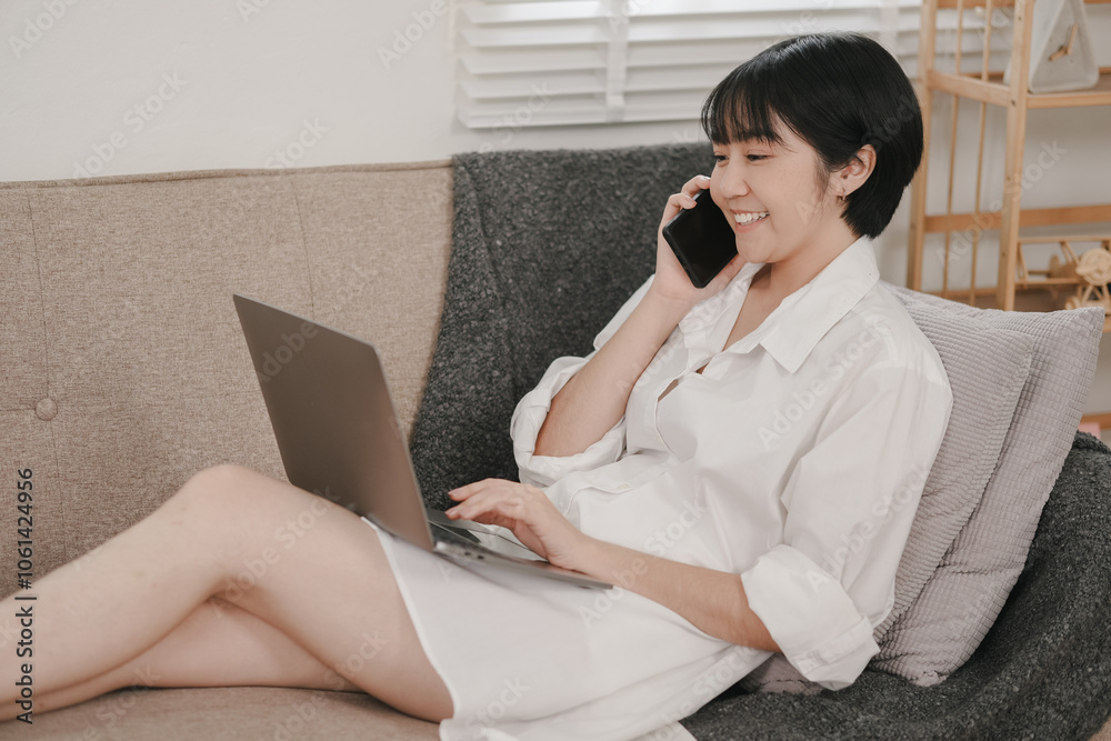 Young woman engages in productive work at home, balancing casual comfort with professionalism while using laptop and phone