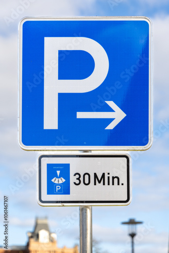 A blue parking sign indicating a 30-minute parking limit with an arrow pointing right. This German street sign highlights parking zones