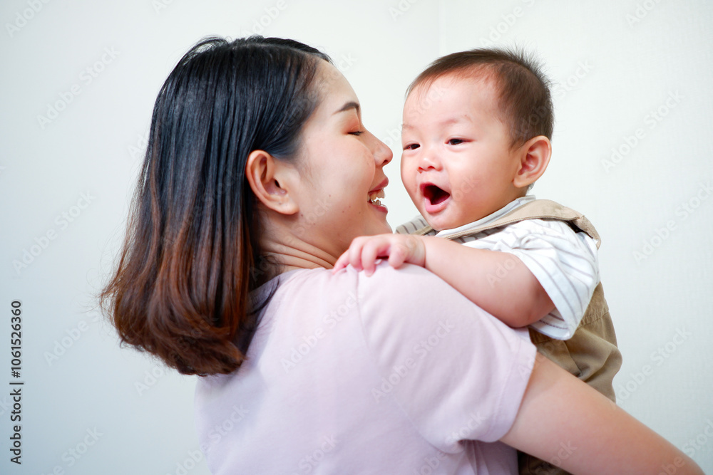 The mother is holding a baby and smiling. The mother is holding a baby and smiling.