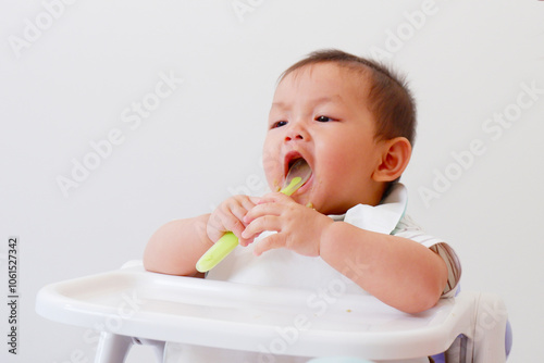 Cute baby sitting eating and smiling.