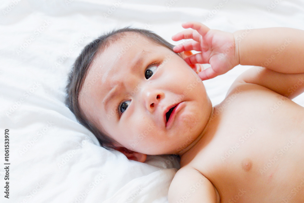 A little boy is crying on the bed. A little boy is crying on the bed.