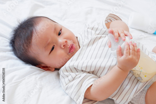 Little boy playing on white bed. Toddler concept.