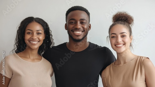 Dark skinned man stands between two beautiful women smile gladfully dressed casually Isolated on white background Diverse people express positive emotions