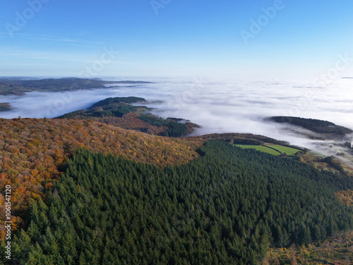 Aerial view of Mont Beuvray in the Morvan in Burgundy, France, with the forest in autumn colours and clouds in the valleys