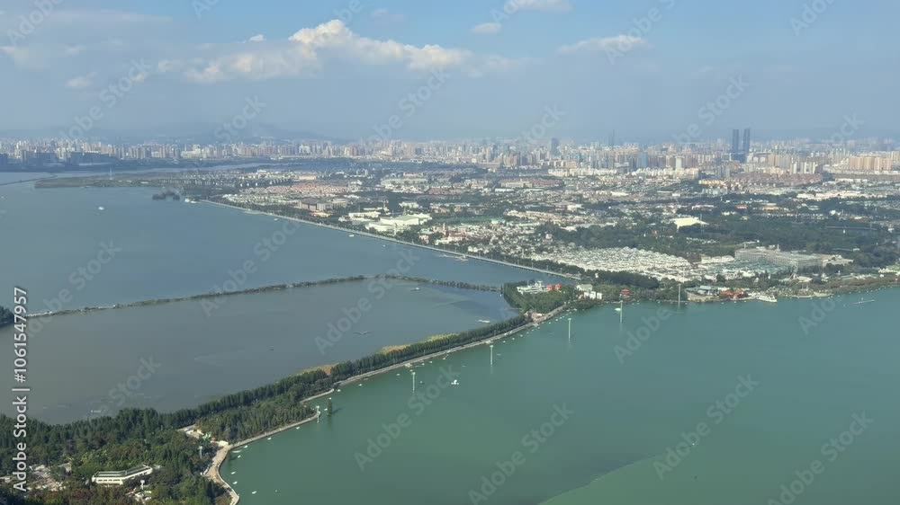 zoom out of Kunming town along a segmented waterway with bridges, featuring densely packed high-rise buildings and smaller structures zoom out of Kunming town along a segmented waterway with bridges, featuring densely packed high-rise buildings and smaller structures