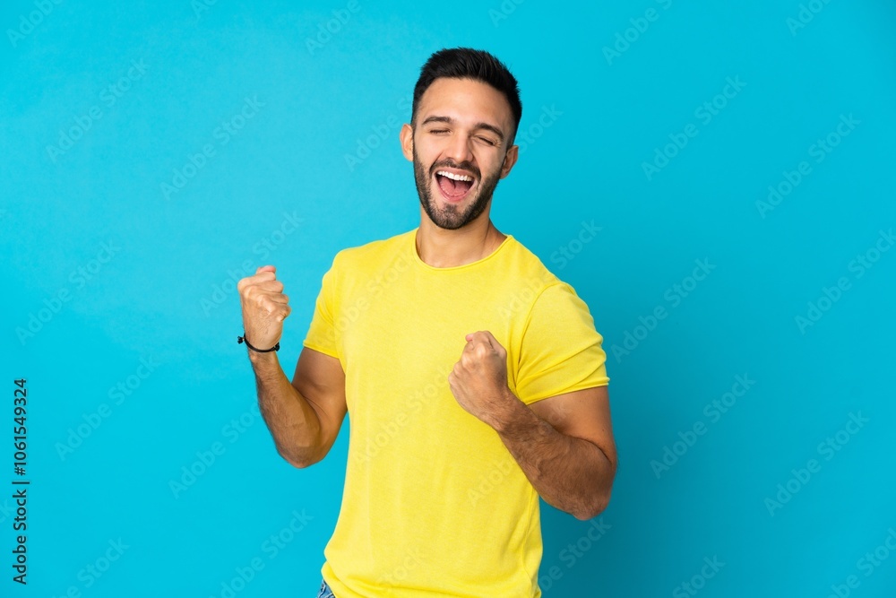 Young caucasian man isolated on blue background celebrating a victory Young caucasian man isolated on blue background celebrating a victory