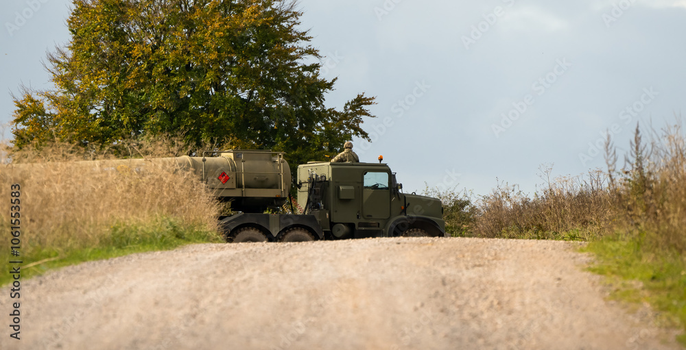 Fototapeta premium British army Oshkosh 6x6 wheeled tanker Logistic Support and Transport Regiments pulling a fuel tanker on a dirt road