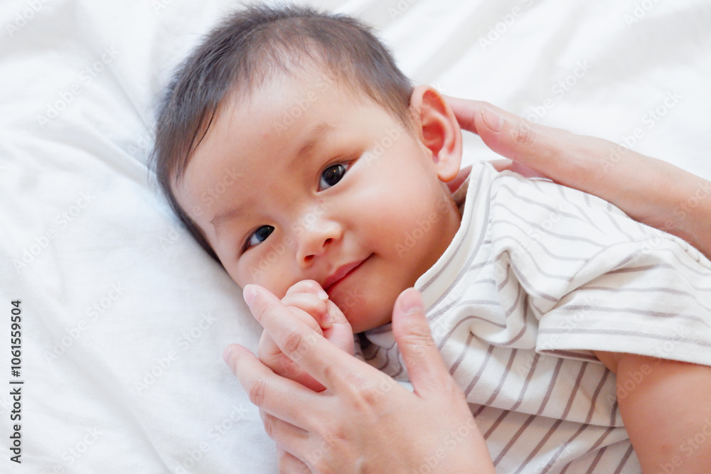 A cute smiling little baby is sleeping on a white bed. A cute smiling little baby is sleeping on a white bed.