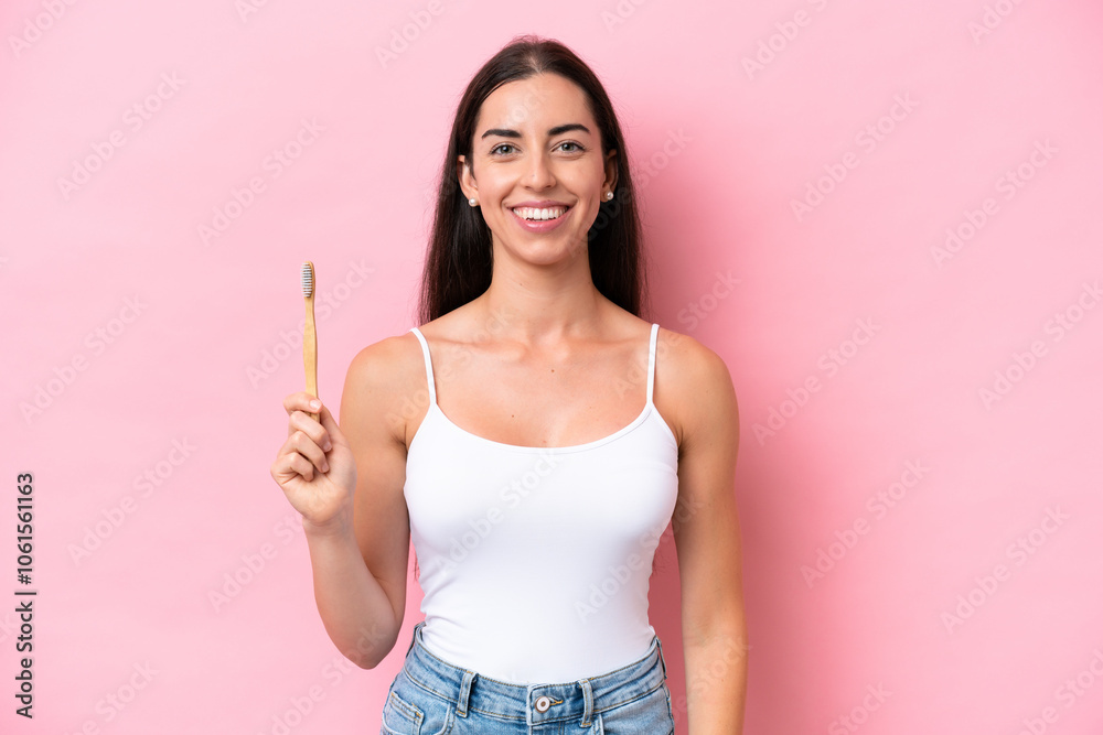 Young caucasian woman brushing teeth isolated on pink background smiling a lot Young caucasian woman brushing teeth isolated on pink background smiling a lot