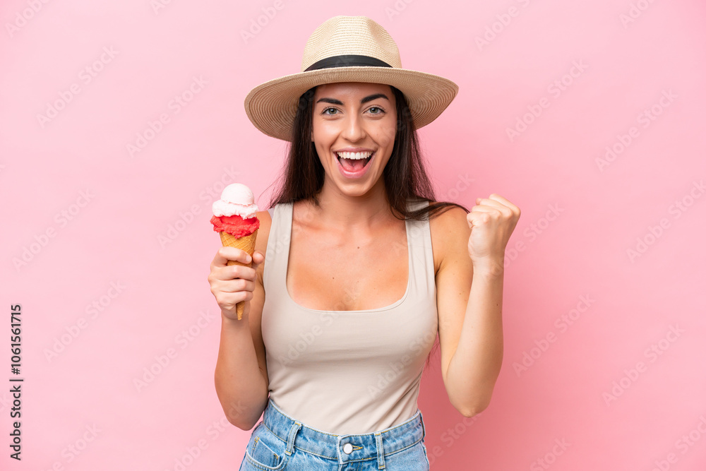 Young caucasian woman with a cornet ice cream isolated on pink background celebrating a victory in winner position Young caucasian woman with a cornet ice cream isolated on pink background celebrating a victory in winner position