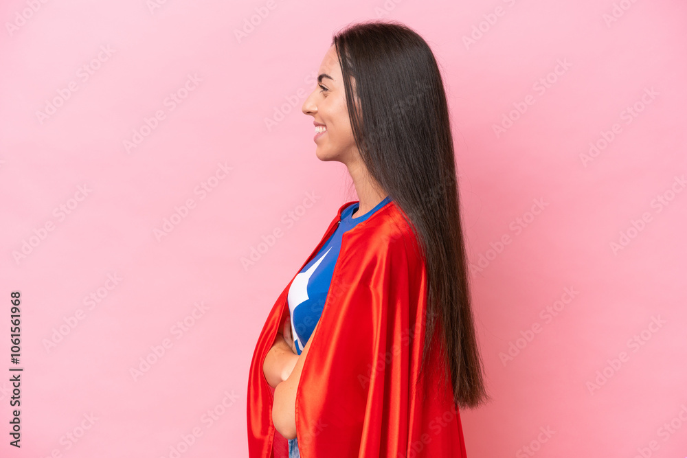 Super Hero Caucasian woman isolated on pink background in lateral position Super Hero Caucasian woman isolated on pink background in lateral position