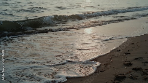 Wallpaper Mural Sunlight glimmers on gentle sea waves washing over a tranquil beach at dawn, creating a reflective mood. Torontodigital.ca