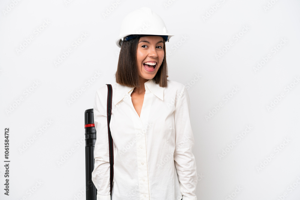 Young architect woman with helmet and holding blueprints isolated on white background with surprise facial expression Young architect woman with helmet and holding blueprints isolated on white background with surprise facial expression