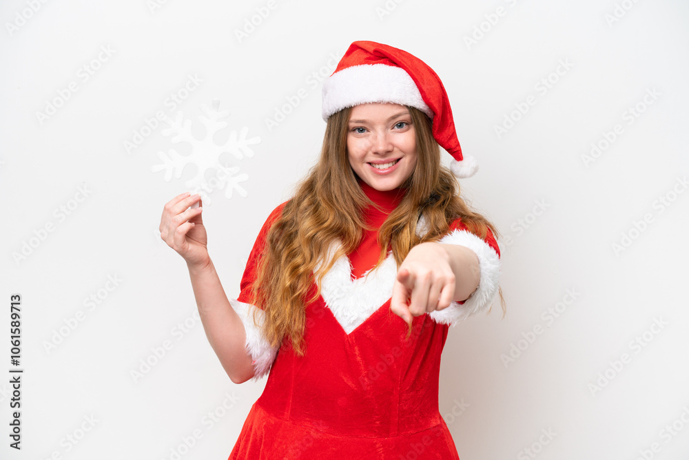 Young caucasian woman with Christmas dress holding snowflake isolated on white background points finger at you with a confident expression Young caucasian woman with Christmas dress holding snowflake isolated on white background points finger at you with a confident expression