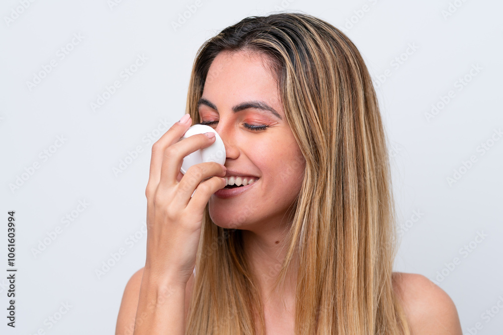 Young caucasian woman isolated on white background with moisturizer and smelling it Young caucasian woman isolated on white background with moisturizer and smelling it