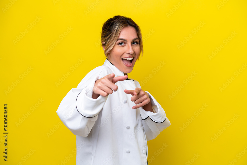 Uruguayan chef woman isolated on yellow background pointing to the front and smiling Uruguayan chef woman isolated on yellow background pointing to the front and smiling