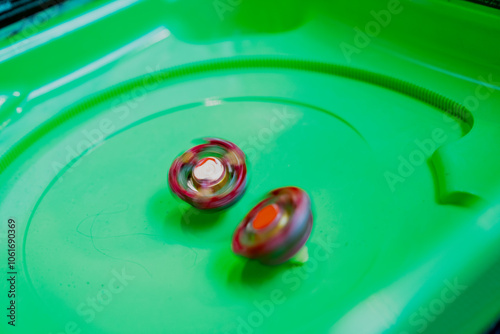 Red beyblade toys battle close up in a dynamic match on green beyblade stadium photo