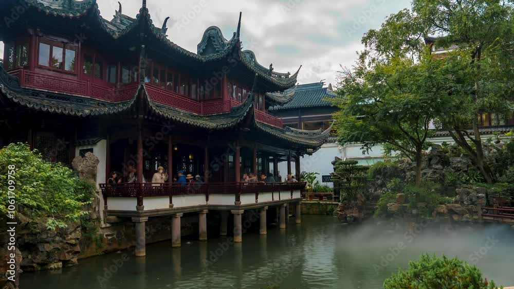 Yu Garden in Shanghai features traditional Chinese architecture, lush greenery, and a tranquil pond, with visitors adding a lively touch. Yu Garden in Shanghai features traditional Chinese architecture, lush greenery, and a tranquil pond, with visitors adding a lively touch.