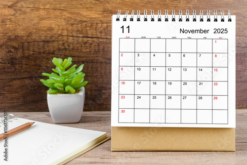 November 2025 desk calendar on table.