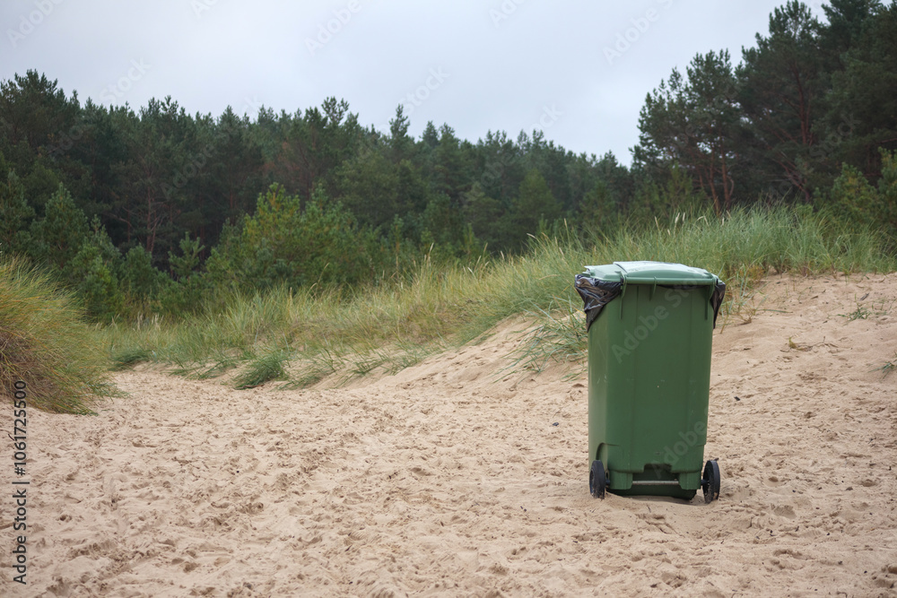green garbage can in the sand of the sea beach
green garbage can in the sand of the sea beach