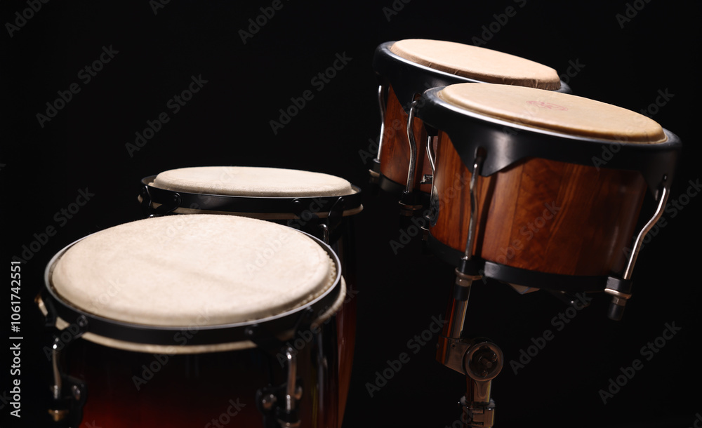 Different drums on a black background, percussion musical instruments