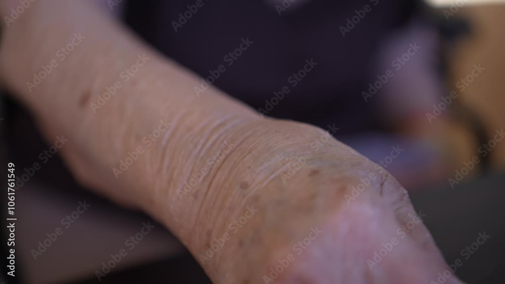Closeup of an elderly persons hands holding playing cards. Their wrinkled skin and age are visible, highlighting the passage of time and the enjoyment of simple pleasures. Closeup of an elderly persons hands holding playing cards. Their wrinkled skin and age are visible, highlighting the passage of time and the enjoyment of simple pleasures.